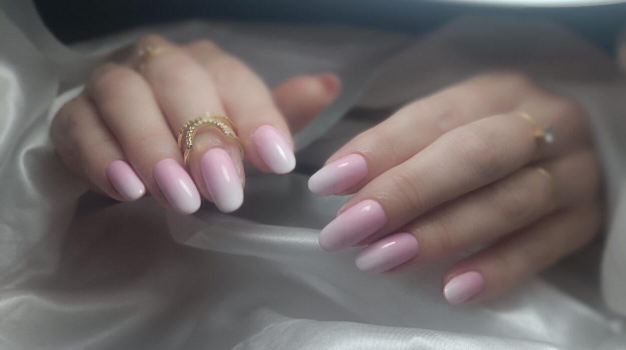 Gros plan d'une manucure professionnelle aux ongles longs et brillants, illustrant le savoir-faire en prothésie ongulaire