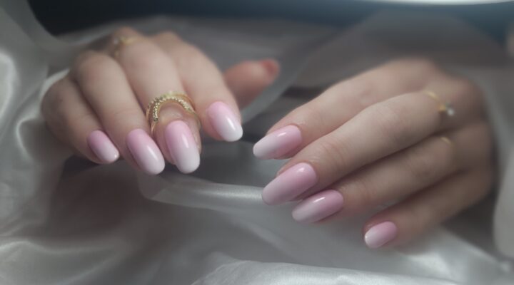 Gros plan d'une manucure professionnelle aux ongles longs et brillants, illustrant le savoir-faire en prothésie ongulaire