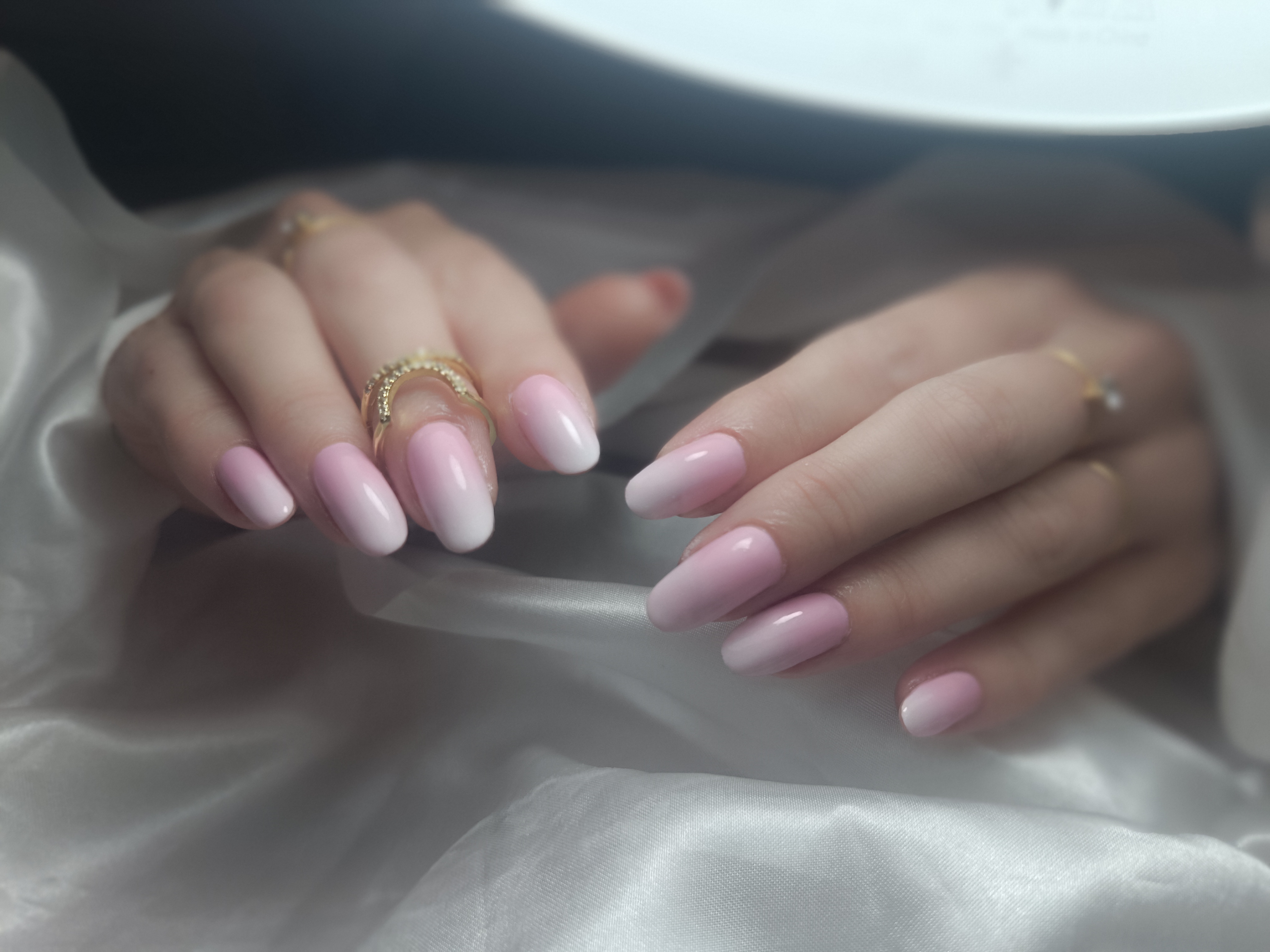 Gros plan d'une manucure professionnelle aux ongles longs et brillants, illustrant le savoir-faire en prothésie ongulaire